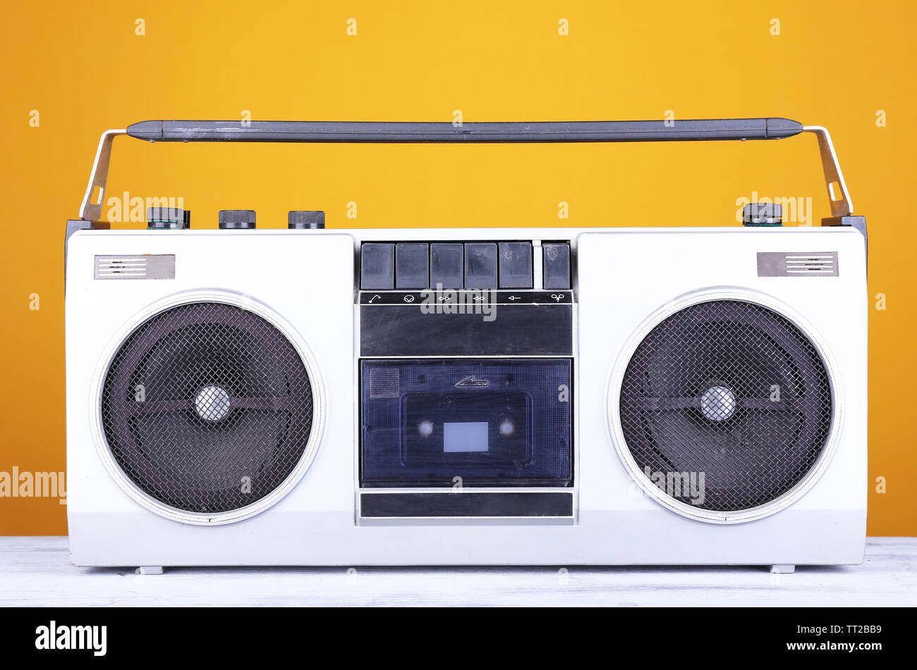 Retro cassette stereo recorder on table on yellow background Stock Photo