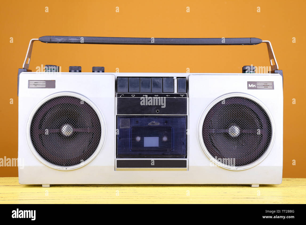 Retro cassette stereo recorder on table on yellow background Stock Photo