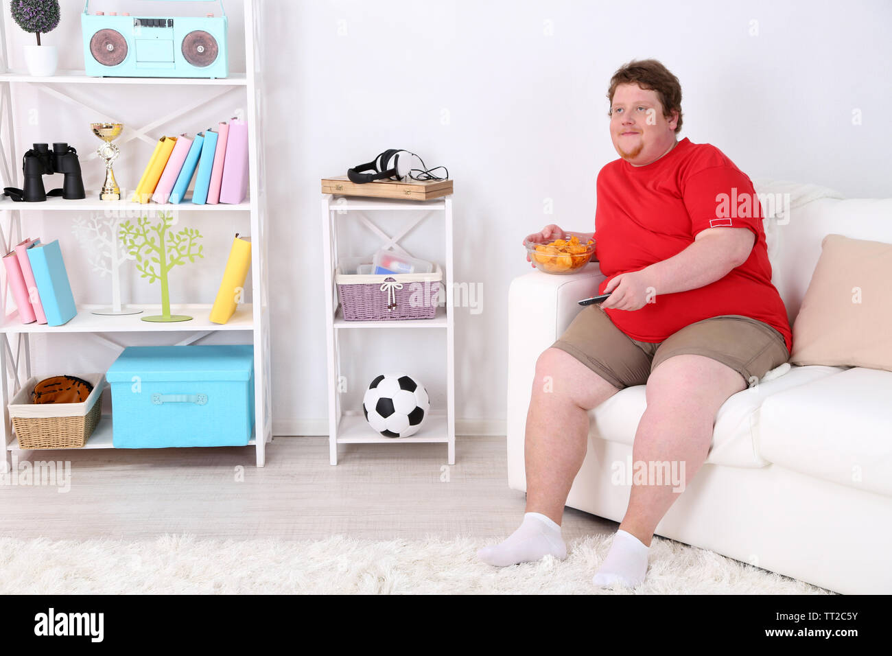 Lazy Overweight Male Sitting On Couch With Chips And Watching