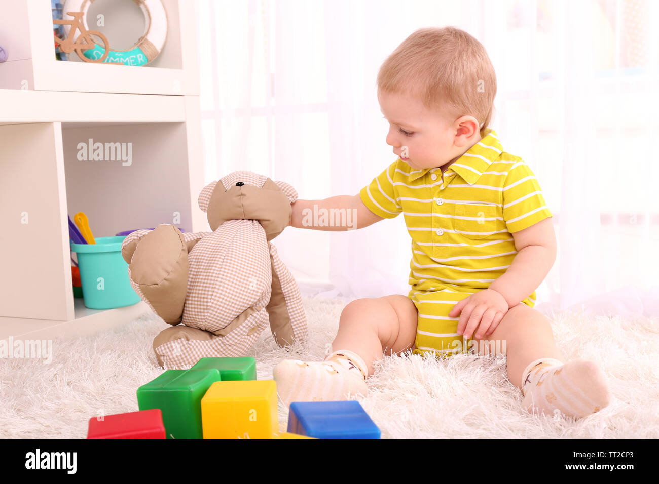 Cute little boy with teddy bear in room Stock Photo - Alamy