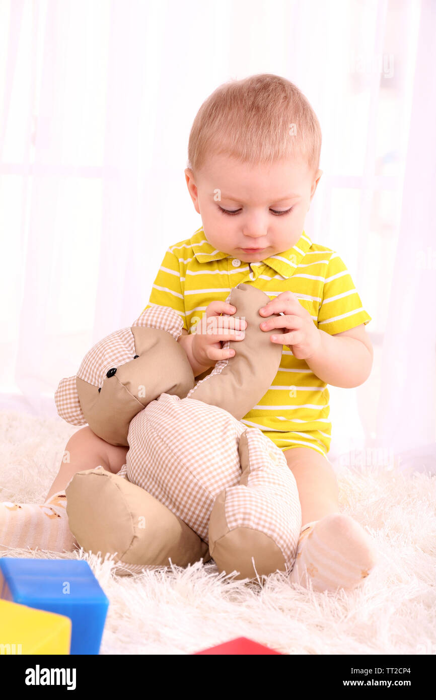 Cute little boy with teddy bear in room Stock Photo - Alamy