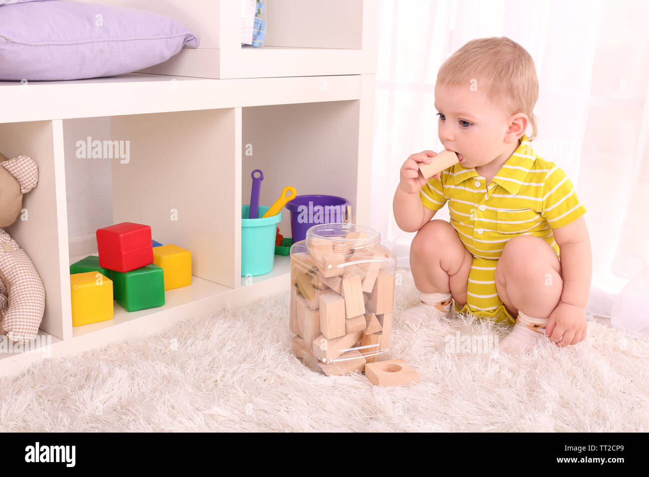 Cute little boy with wooden toy blocks in room Stock Photo - Alamy