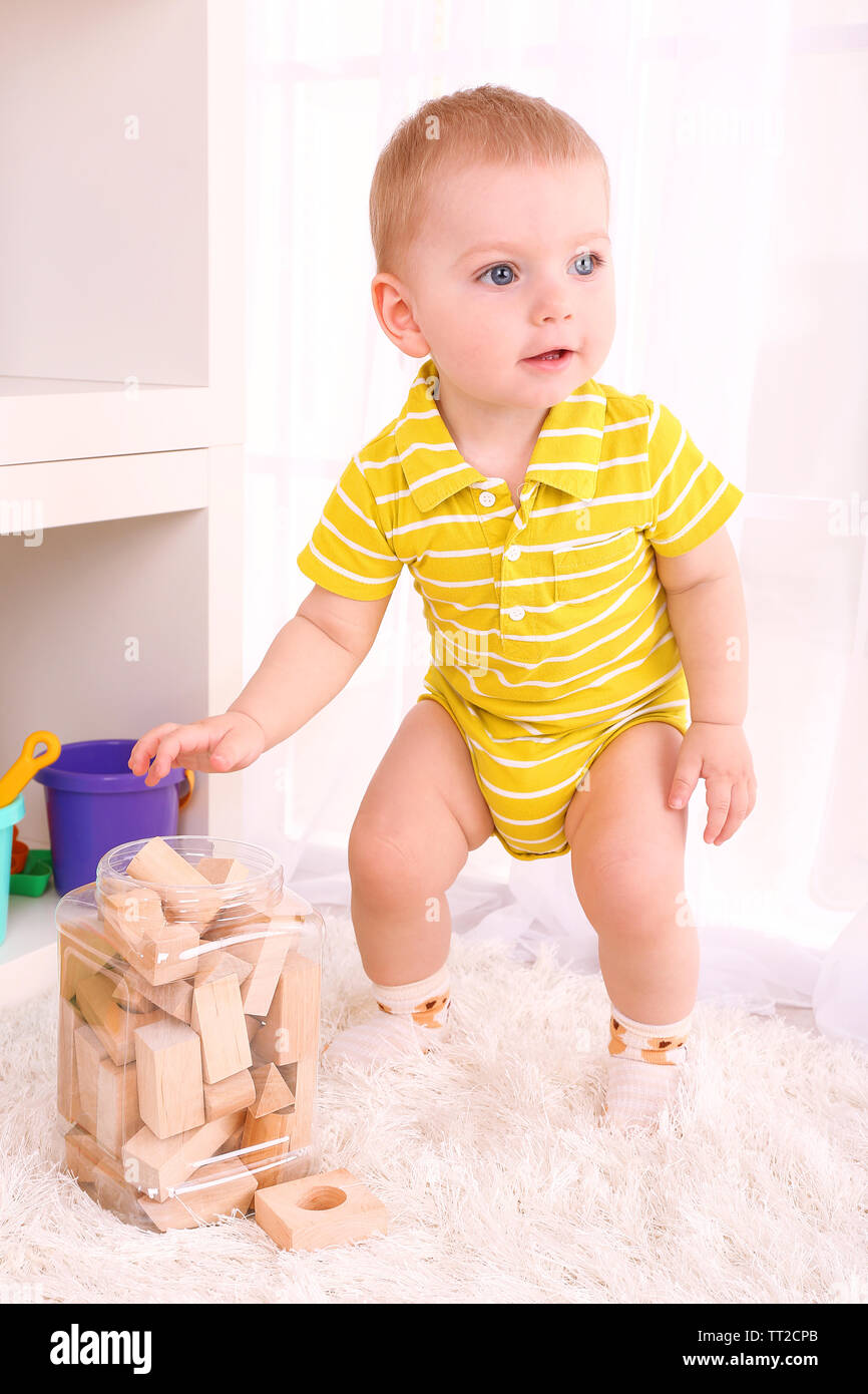Cute little boy with wooden toy blocks in room Stock Photo - Alamy