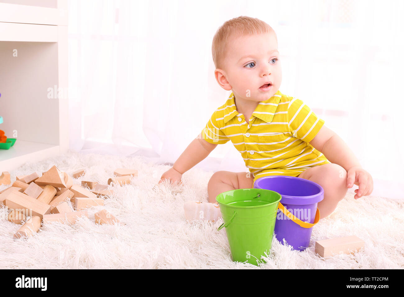 Cute little boy with wooden toy blocks in room Stock Photo - Alamy