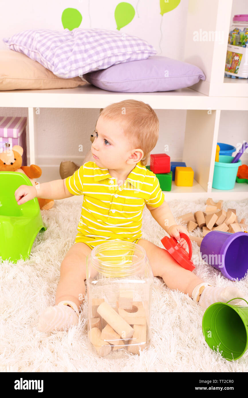 Cute little boy with wooden toy blocks in room Stock Photo - Alamy