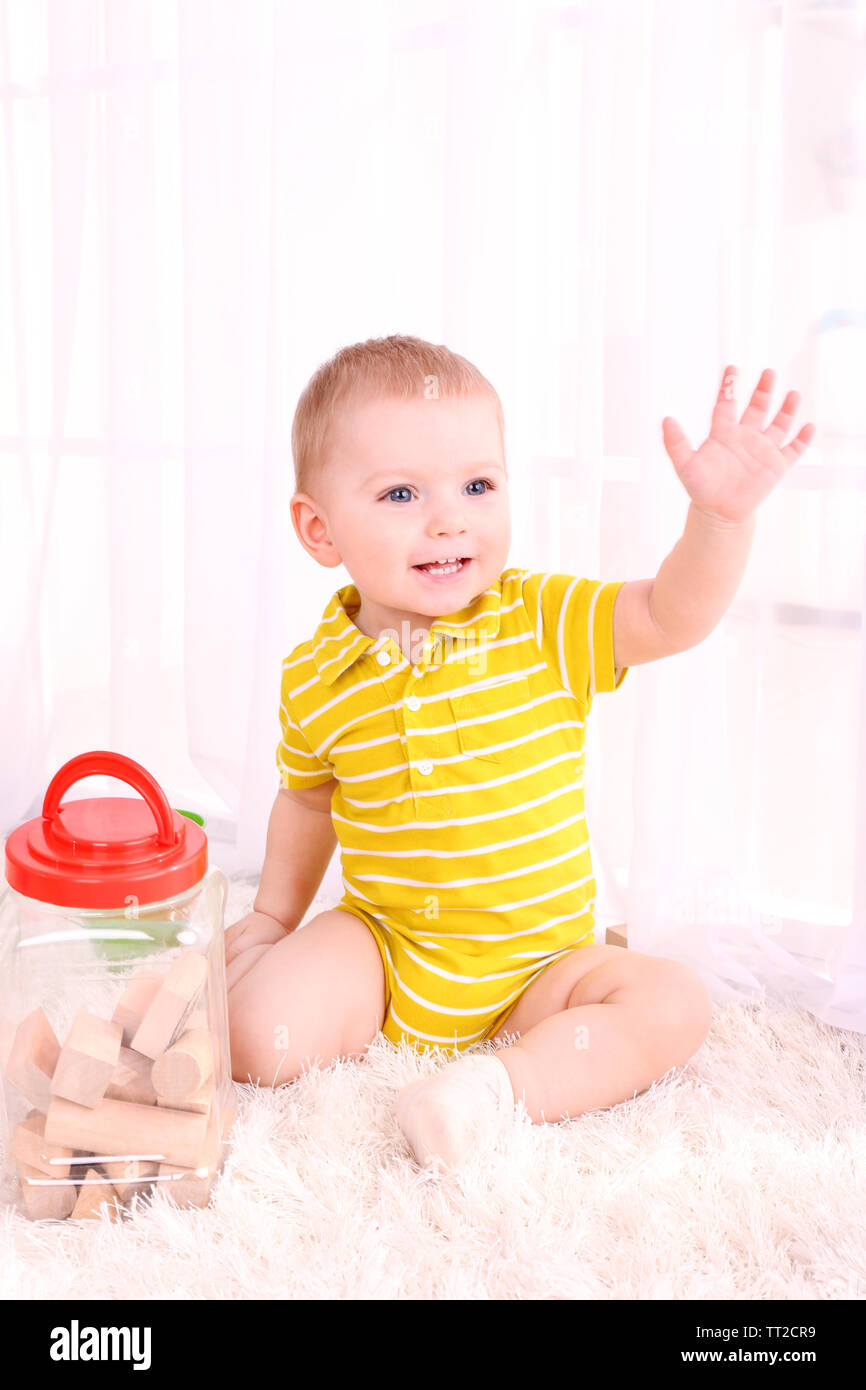 Cute little boy with wooden toy blocks in room Stock Photo - Alamy