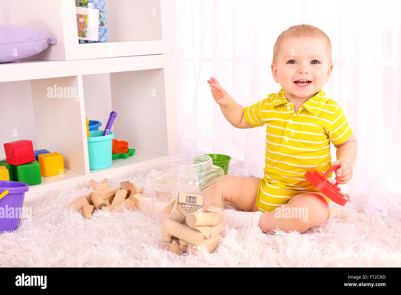 Cute little boy with wooden toy blocks in room Stock Photo - Alamy