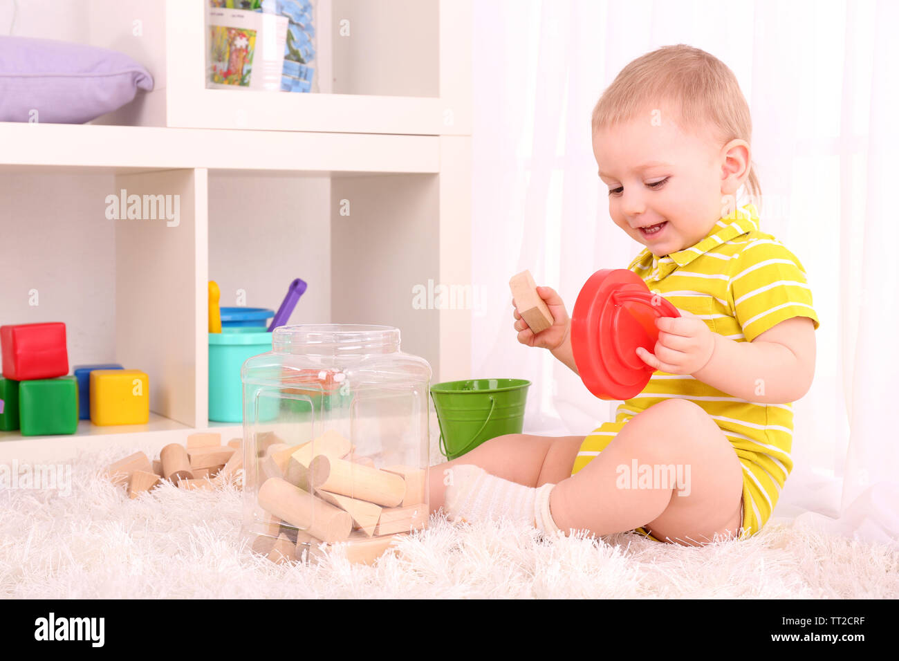 Cute little boy with wooden toy blocks in room Stock Photo - Alamy