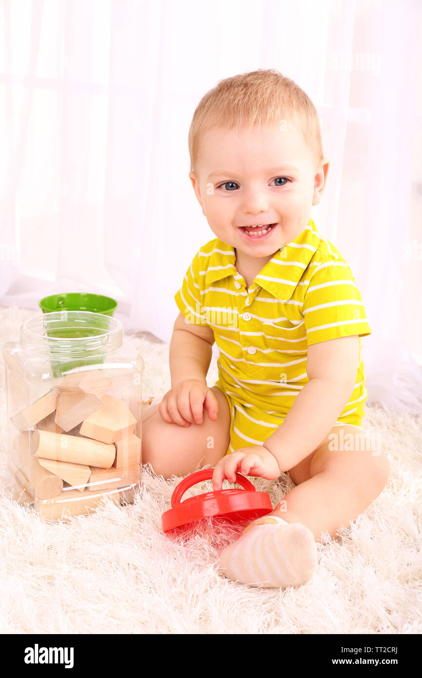 Cute little boy with wooden toy blocks in room Stock Photo - Alamy