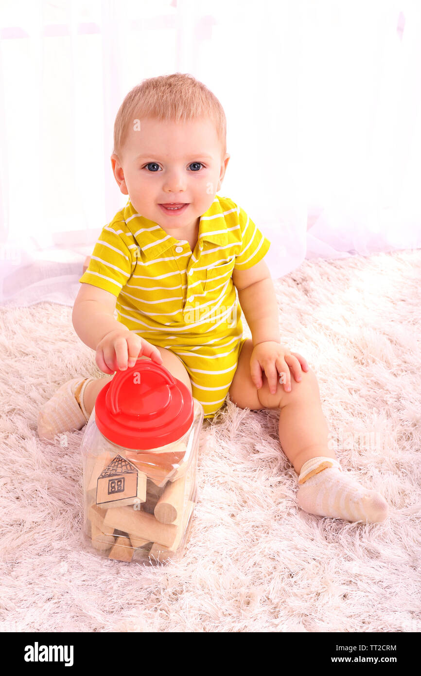 Cute little boy with wooden toy blocks in room Stock Photo - Alamy