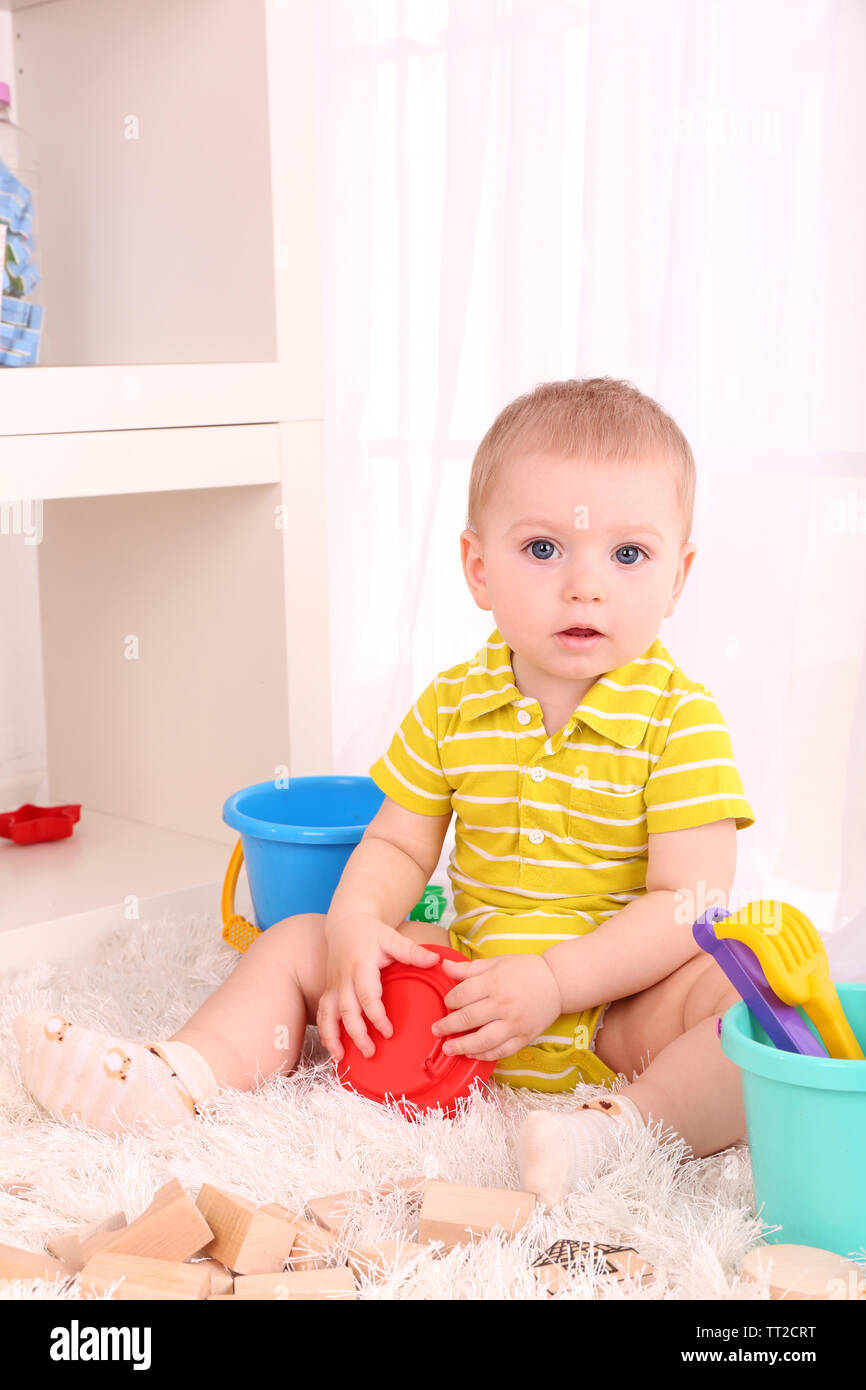 Cute little boy with wooden toy blocks in room Stock Photo - Alamy