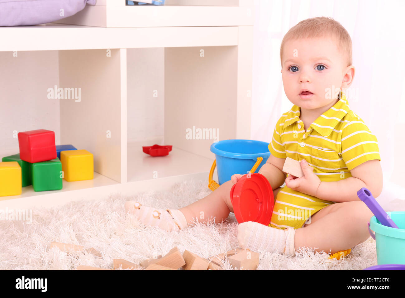 Cute little boy with wooden toy blocks in room Stock Photo - Alamy