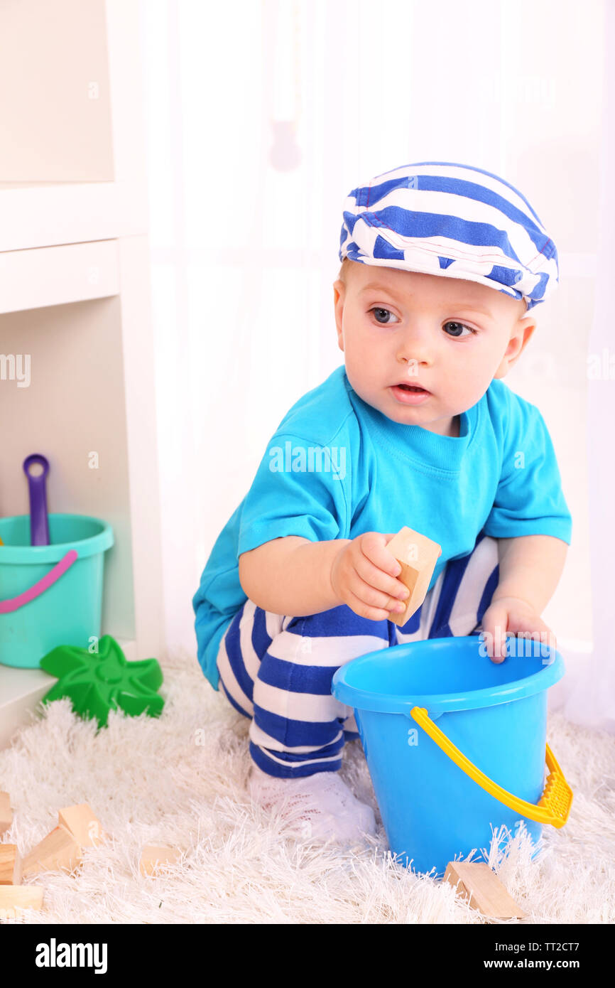 Cute little boy with wooden toy blocks in room Stock Photo - Alamy