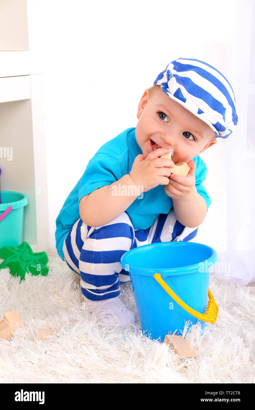 Cute little boy with wooden toy blocks in room Stock Photo - Alamy