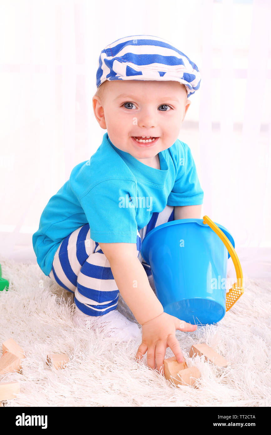 Cute little boy with wooden toy blocks in room Stock Photo - Alamy