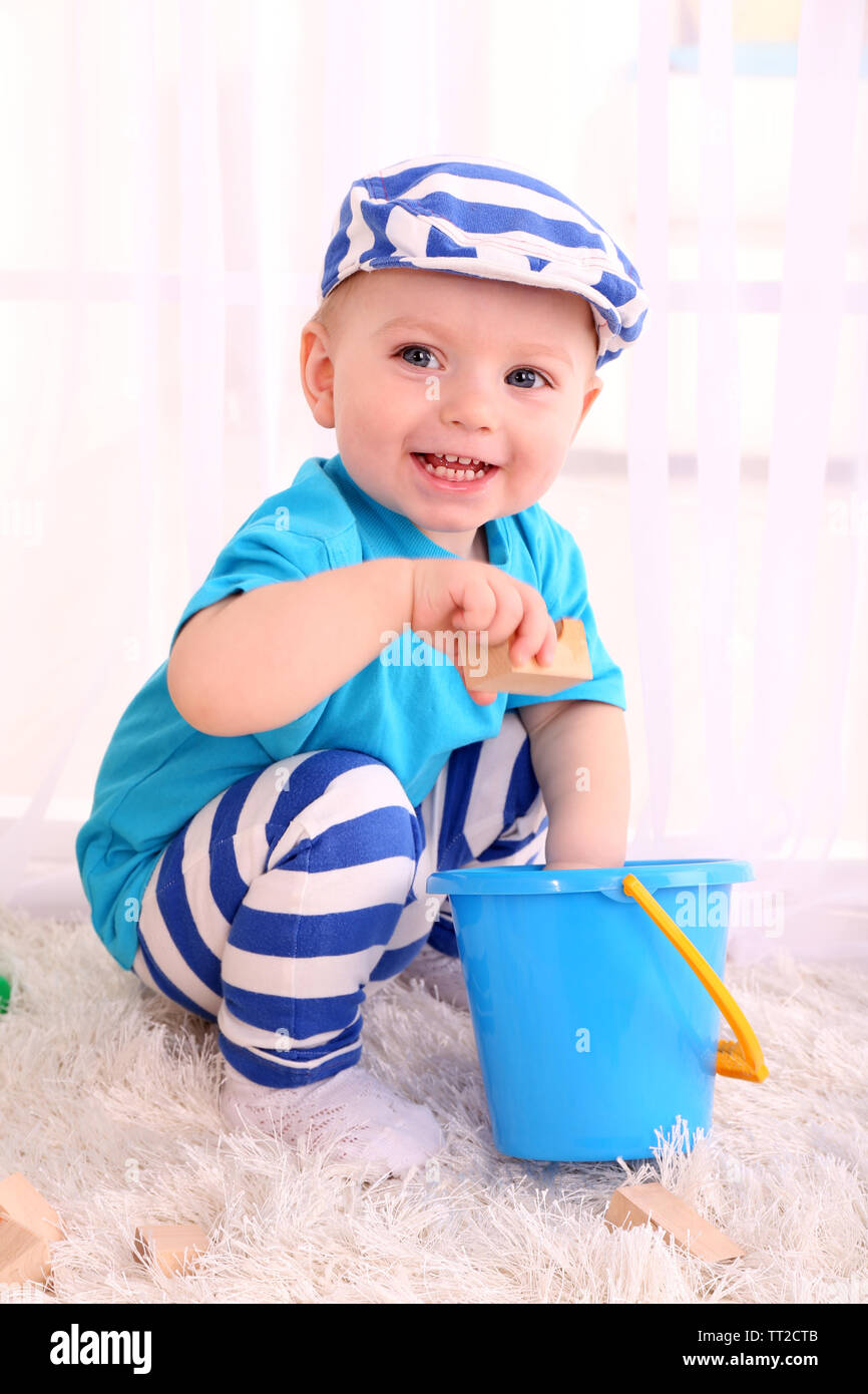 Cute little boy with wooden toy blocks in room Stock Photo - Alamy