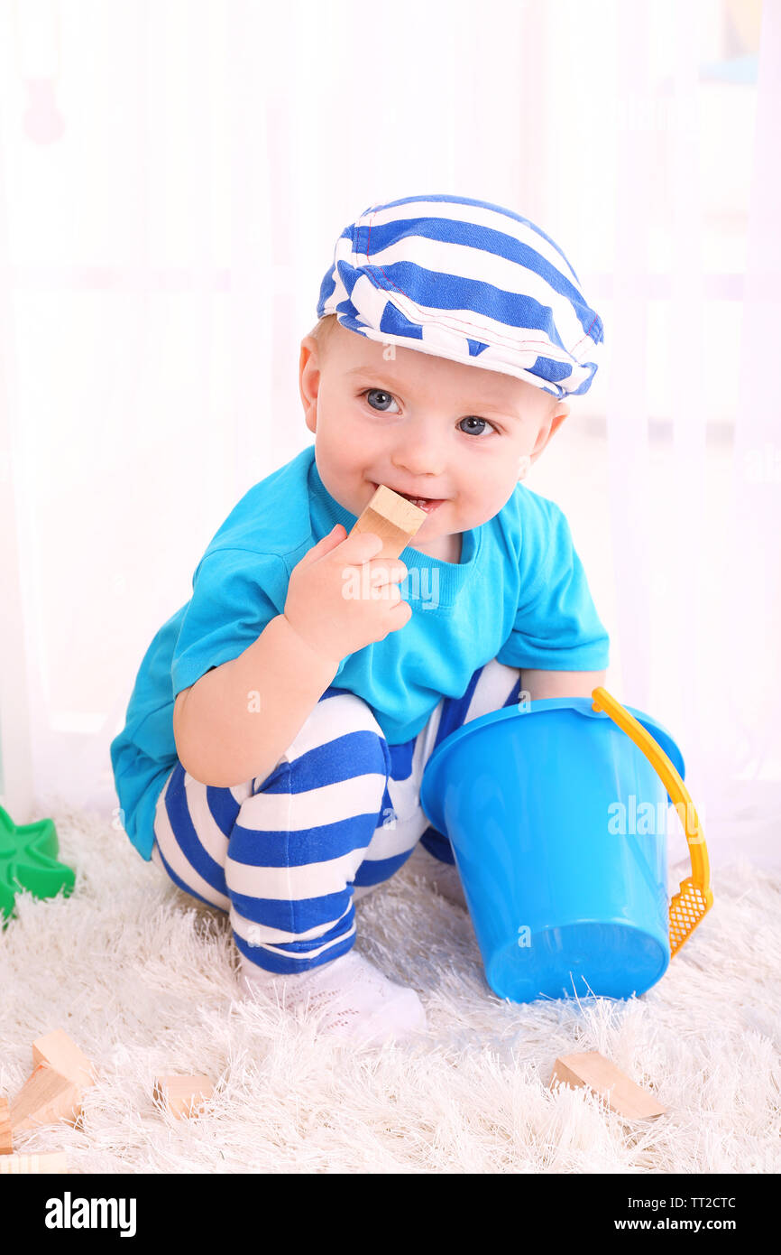 Cute little boy with wooden toy blocks in room Stock Photo - Alamy