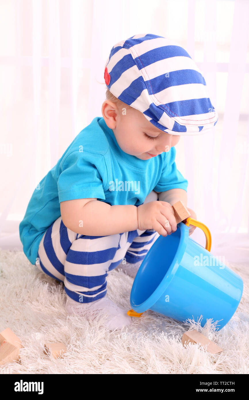Cute little boy with wooden toy blocks in room Stock Photo - Alamy
