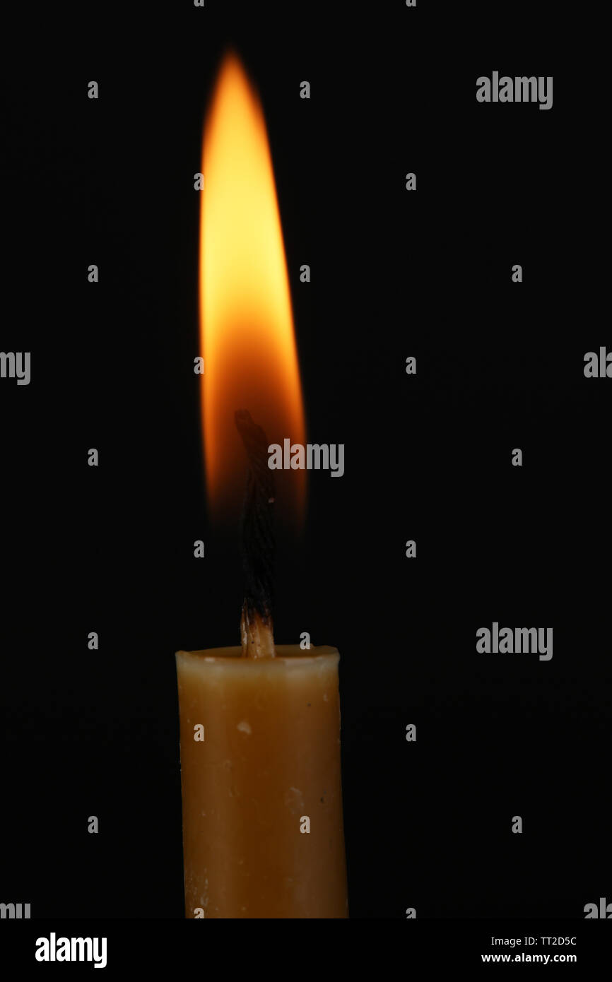 Burning candle on black background Stock Photo