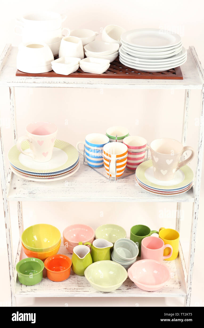 Different tableware on shelf, isolated on white Stock Photo - Alamy