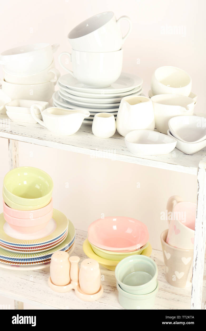 Different tableware on shelf, isolated on white Stock Photo - Alamy