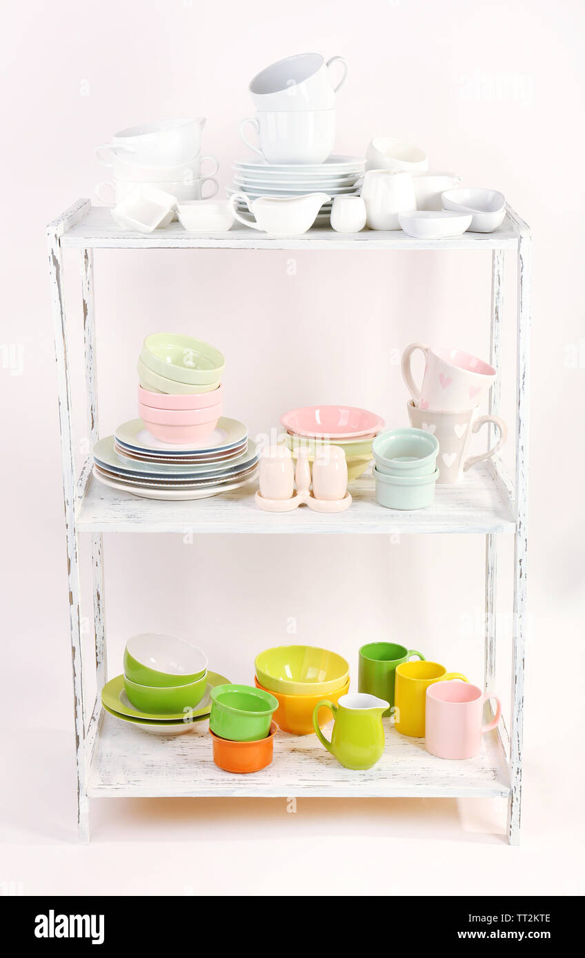 Different tableware on shelf, isolated on white Stock Photo - Alamy