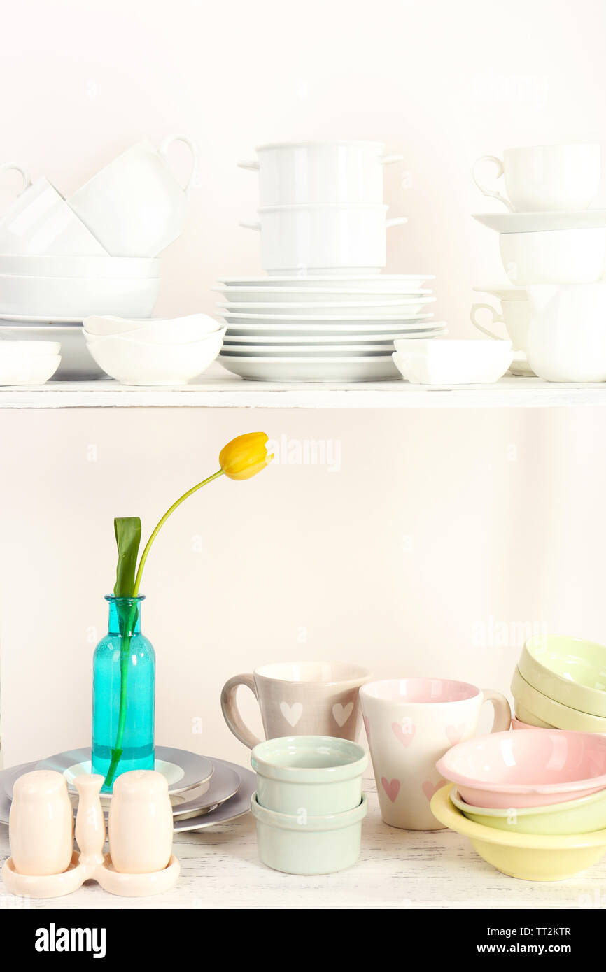 Different tableware on shelf, isolated on white Stock Photo - Alamy