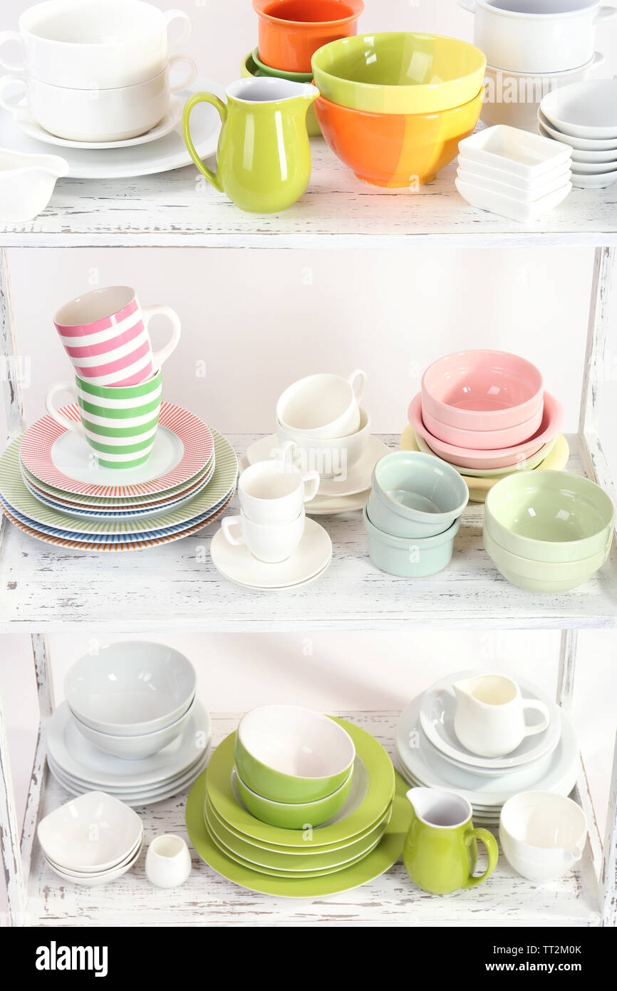 Different tableware on shelf, isolated on white Stock Photo - Alamy