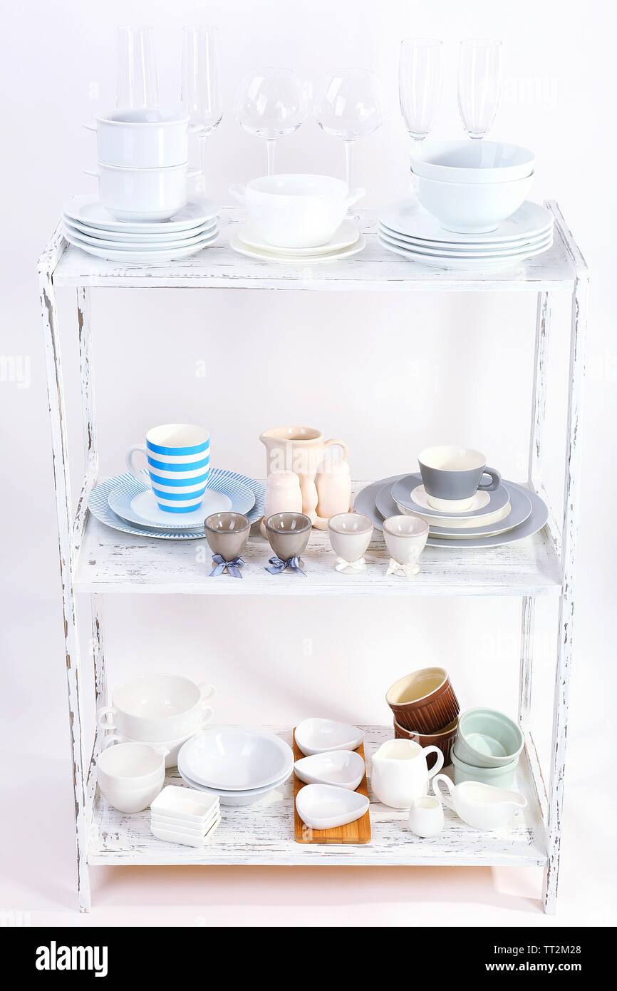Different tableware on shelf, isolated on white Stock Photo - Alamy
