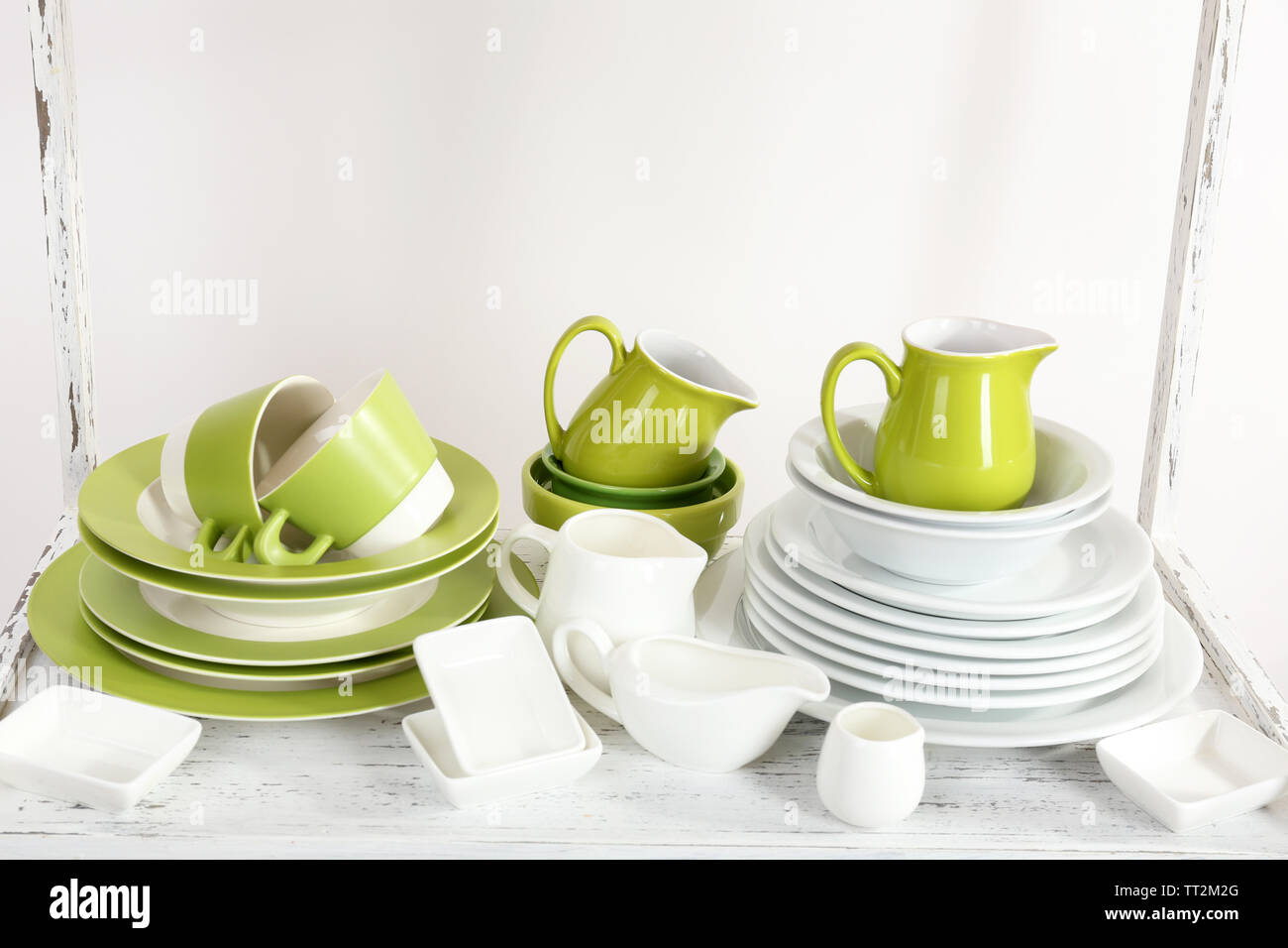 Different tableware on shelf, isolated on white Stock Photo - Alamy
