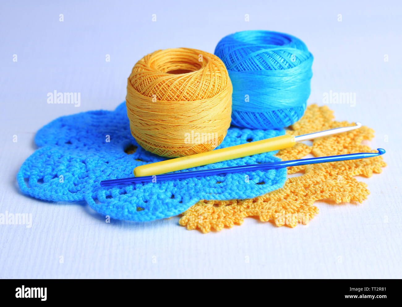 Colorful clews and crochet hooks on light background Stock Photo