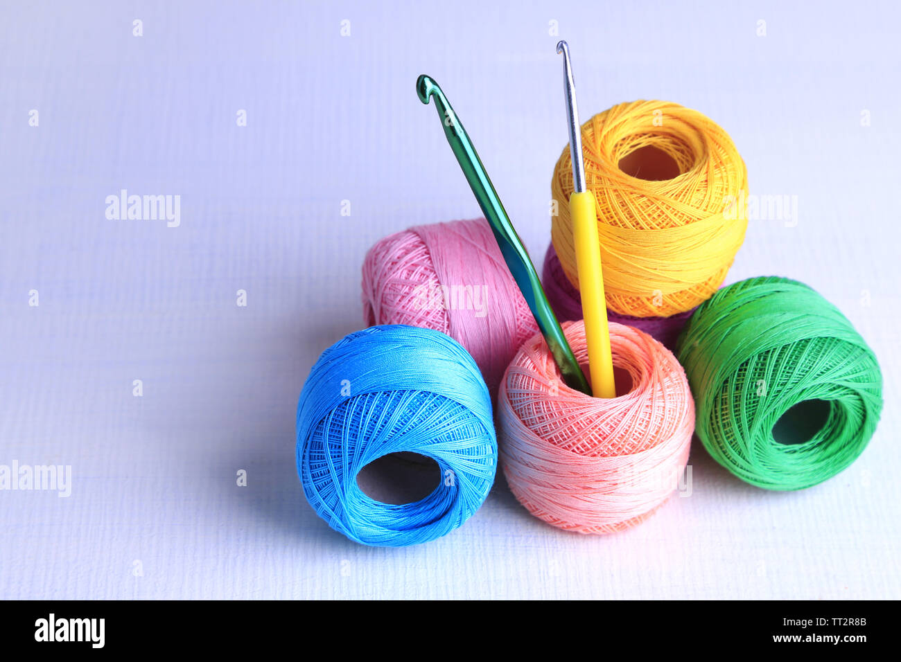Colorful clews and crochet hooks on light background Stock Photo