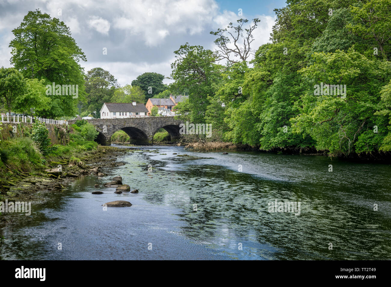 Old stone bridge over a river in the village or Ramelton in Donegal Ireland Stock Photo