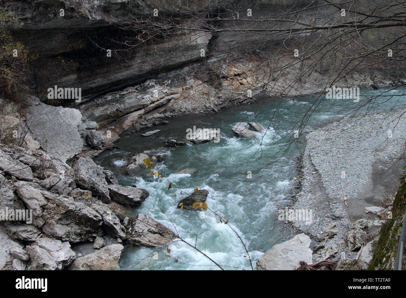 A stormy mountain river flows among the cliffs in the Khadzhokhskaya gorge. Stock Photo