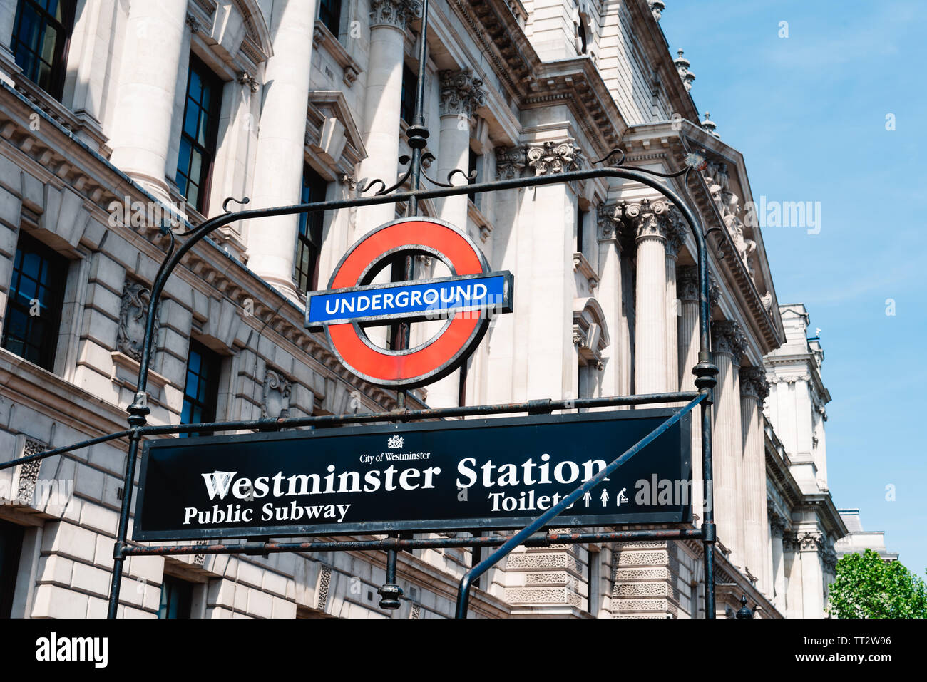 London, UK - May 15, 2019: Low angle view of Underground sign Westminster Station against buildings a sunny day Stock Photo