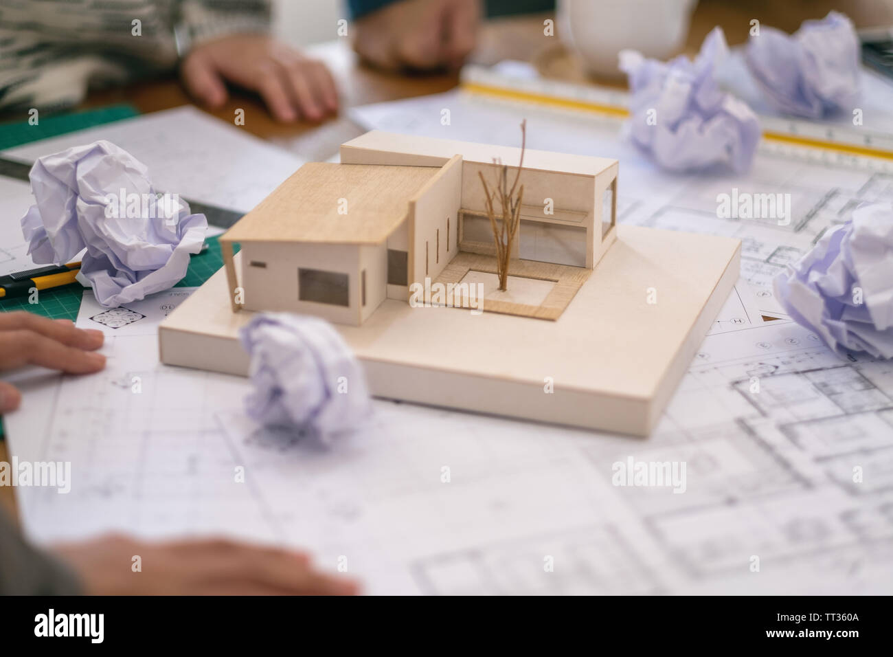 Group of an architect feel stressed after working on architecture model together with shop drawing paper on table in office Stock Photo