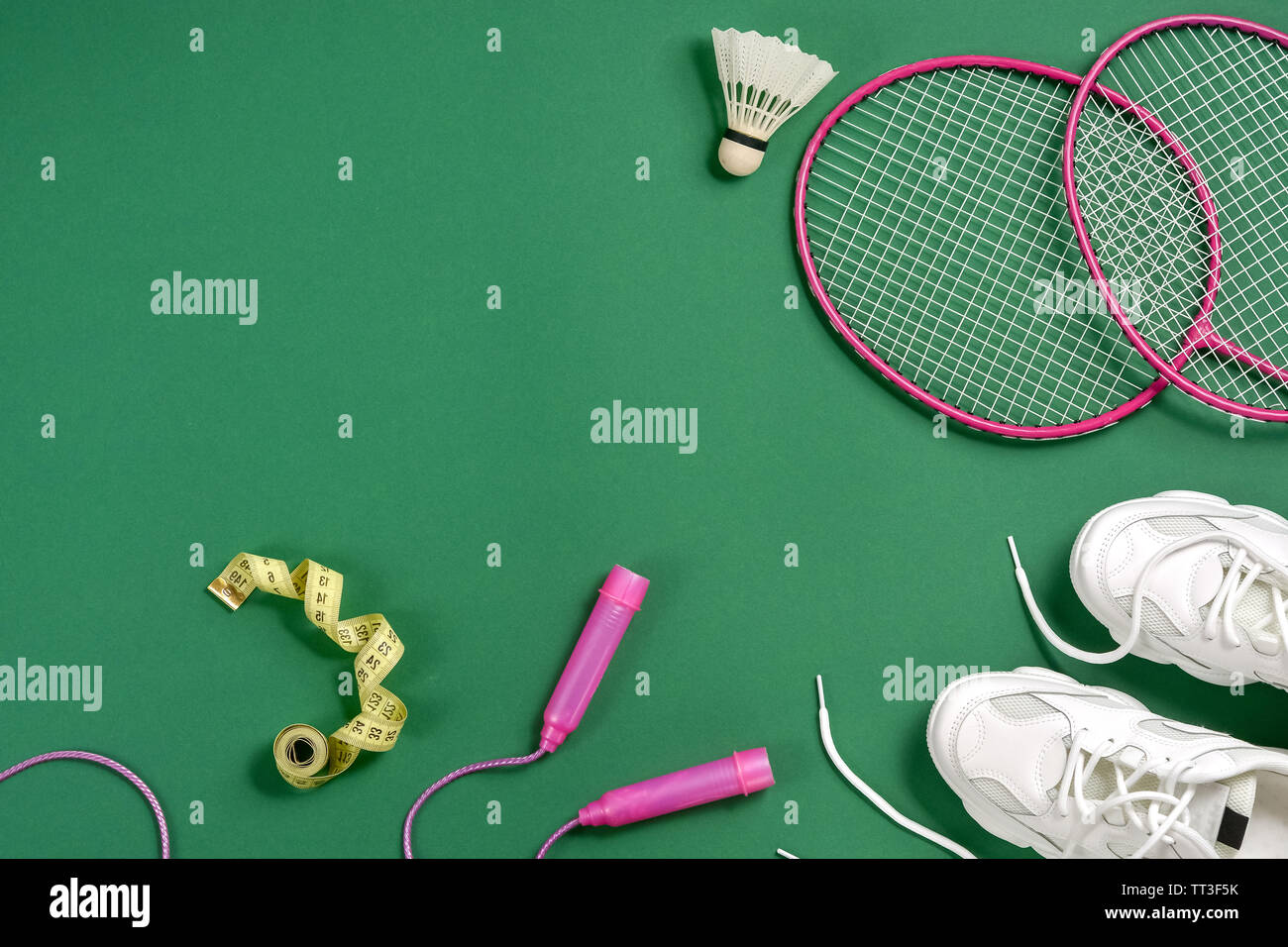 Sports flat lay with shuttlecock and badminton racket, skipping rope,  sneakers and measuring tape on green background. Fitness, sport and healthy  life Stock Photo - Alamy
