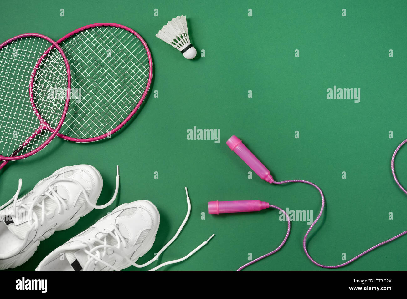 Sports flat lay with shuttlecock and badminton racket, skipping rope,  sneakers on green background. Fitness, sport and healthy lifestyle concept  Stock Photo - Alamy