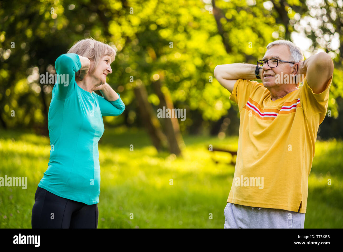 Senior couple is exercising in park. Stock Photo