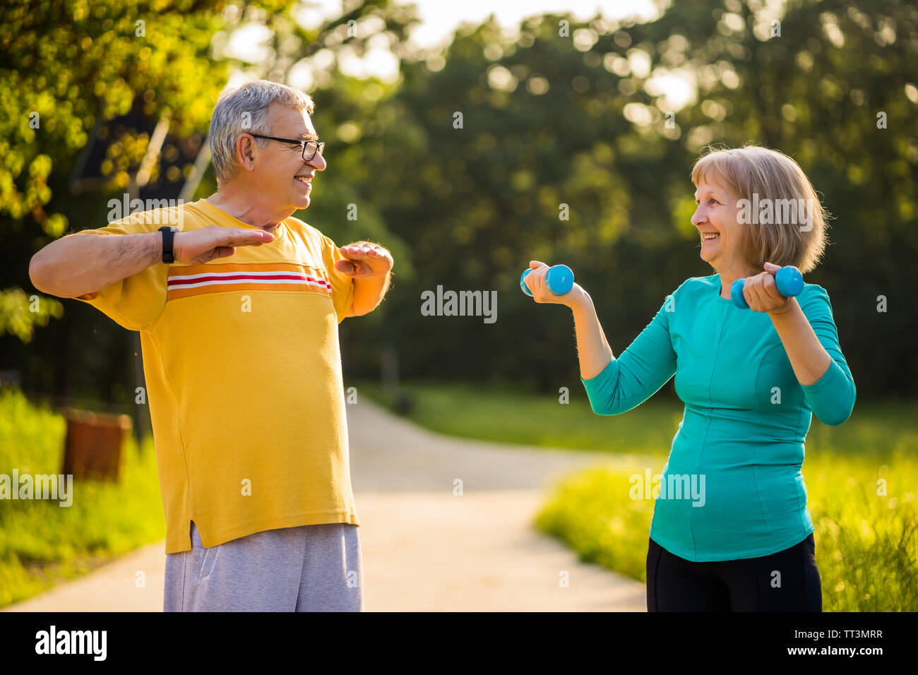 Senior couple is exercising in park. Stock Photo