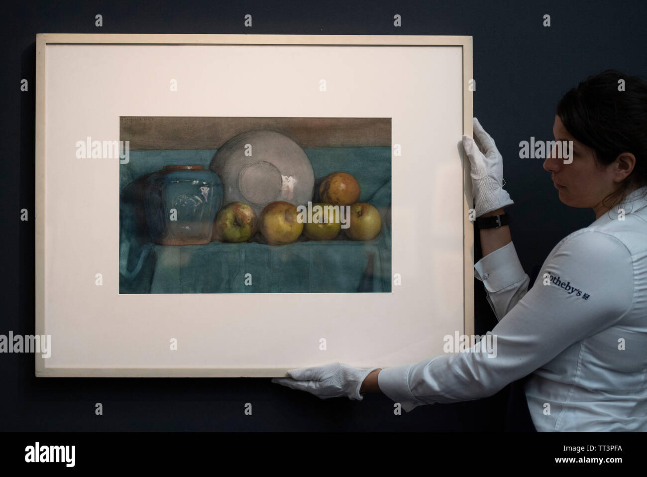 Sotheby’s, London, UK. 14th June 2019. Major Impressionism to Modern British works, some unseen for decades, are previewed for the Sotheby’s summer sale. Image: A Sothebys art handler with Piet Mondrian, Appels, Gemberpot en Bord op een Richel (Apples, Ginger Pot and Plate on a Ledge), estimate £70,000-90,000. Credit: Malcolm Park/Alamy Live News. Stock Photo