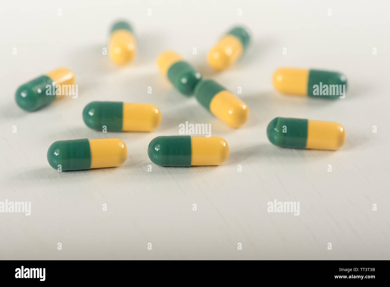 Green, yellow tramadol capsule pills on white background.Pain killer capsules called 'Tramadol HCL'.The medicine for pain relive. Stock Photo