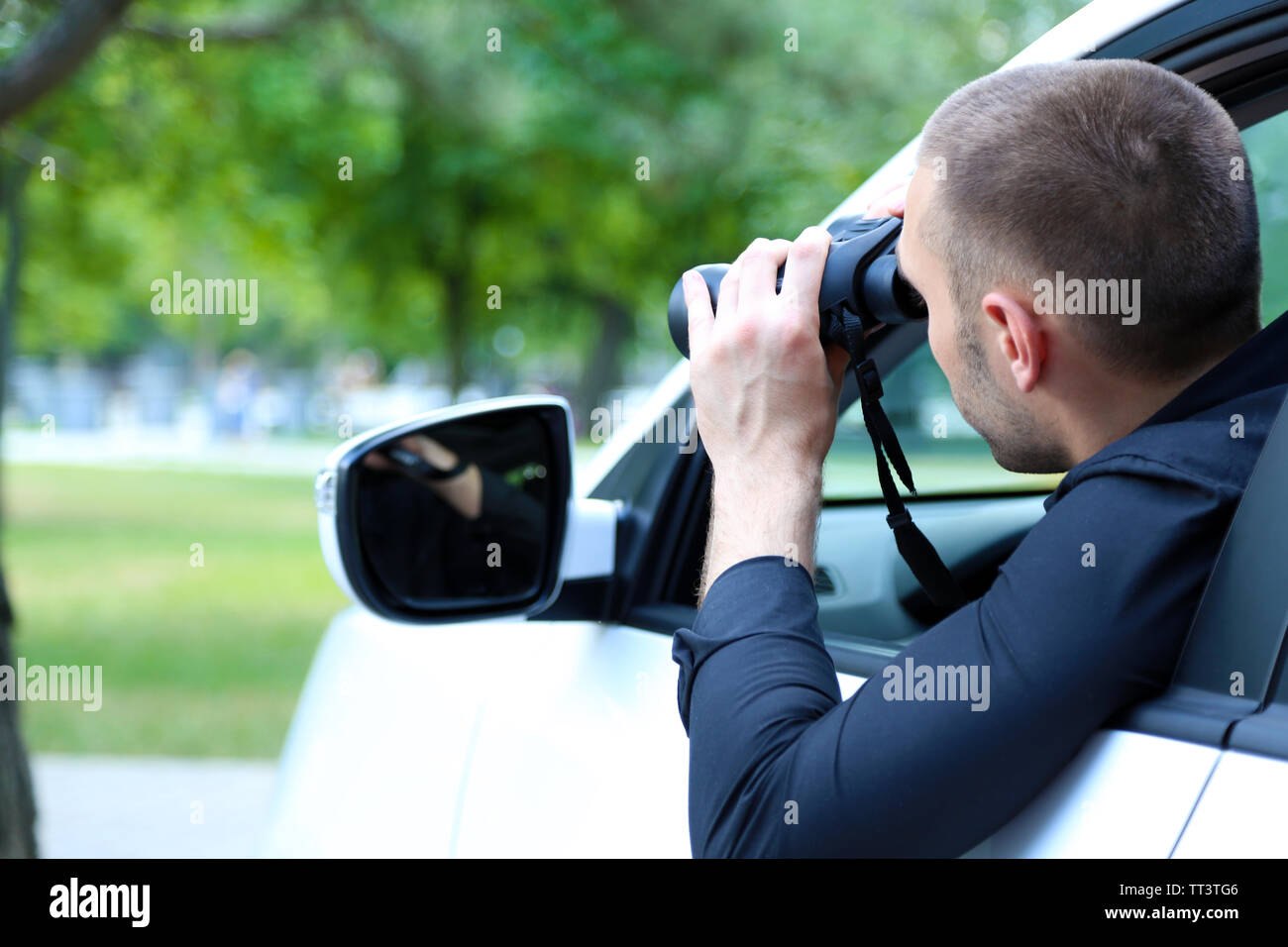 Man in car with binoculars Stock Photo Alamy