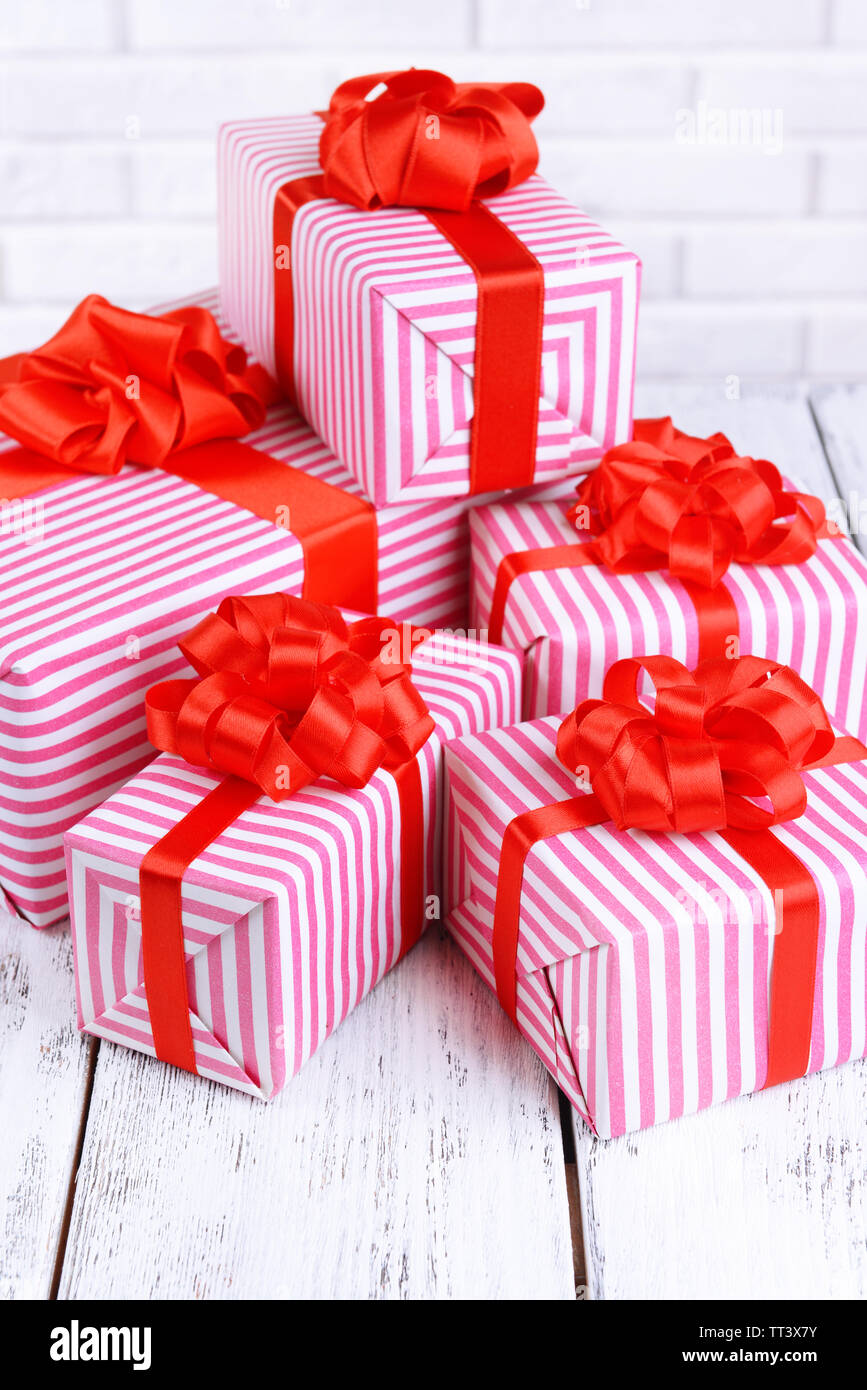 Beautiful gifts on table on brick wall background Stock Photo Alamy