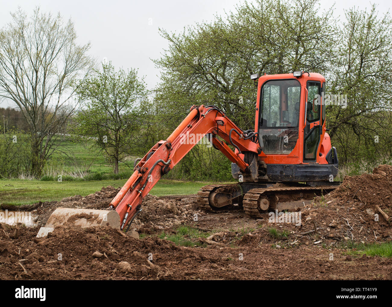 Orange excavator at rural work site. Stock Photo
