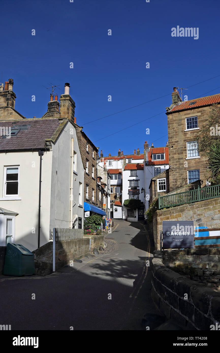 A view from the beck in Robin Hood's Bay, North Yorkshire, UK, looking up New Rd towards the Laurel Inn. Stock Photo