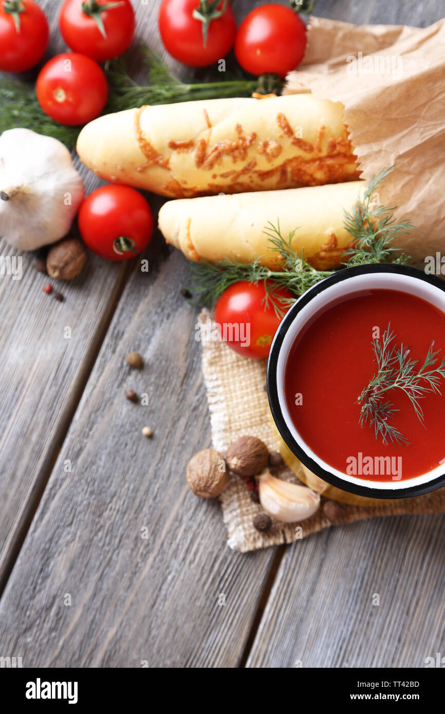 Homemade tomato juice in color mug, bread sticks, spices and fresh ...