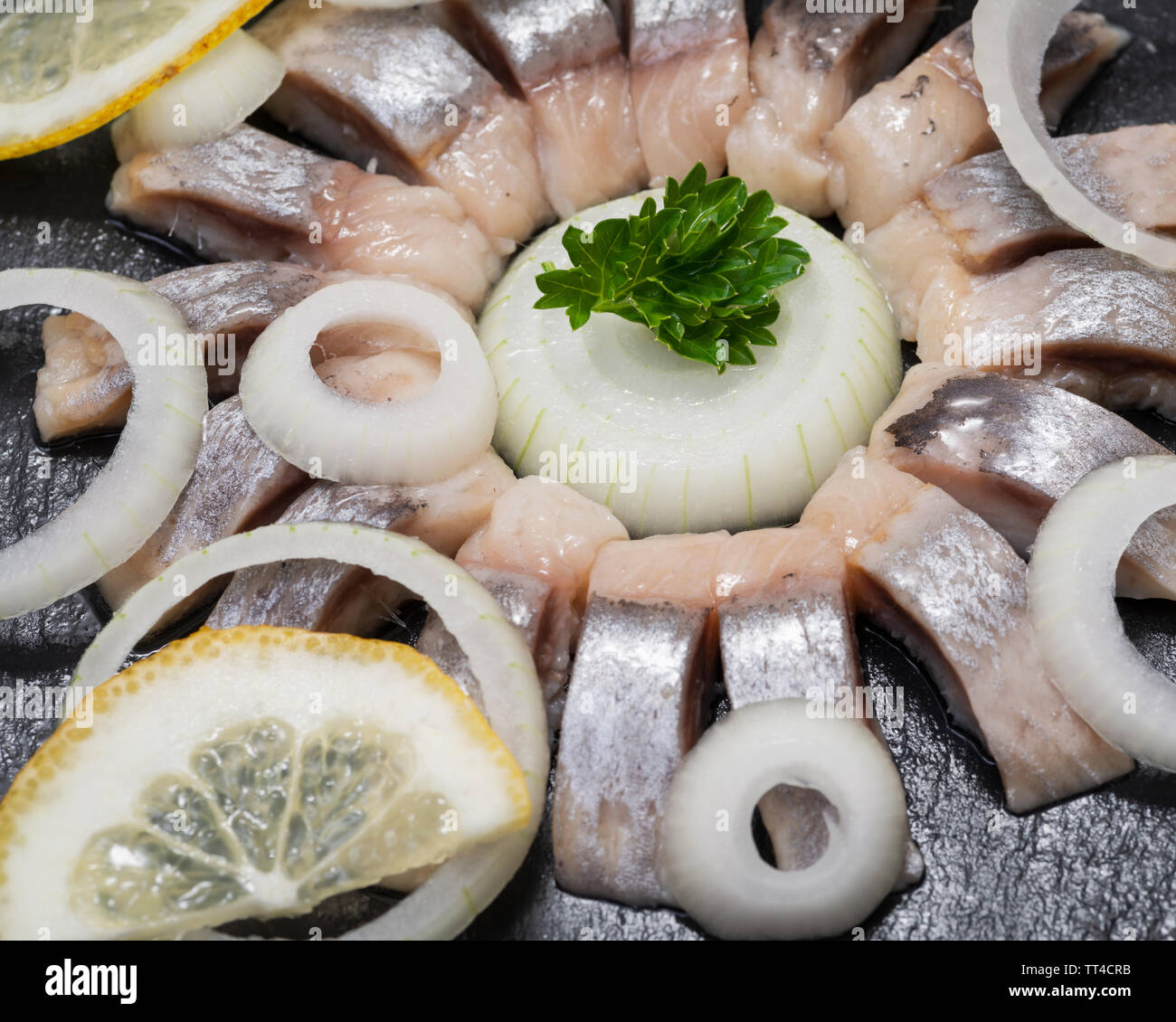 Hollandse Nieuwe Traditional Dutch Food Soused Raw Herring Soaked In Mild Marinade Garnished With Lemon Onion And Parsley On Black Natural Stone Stock Photo Alamy