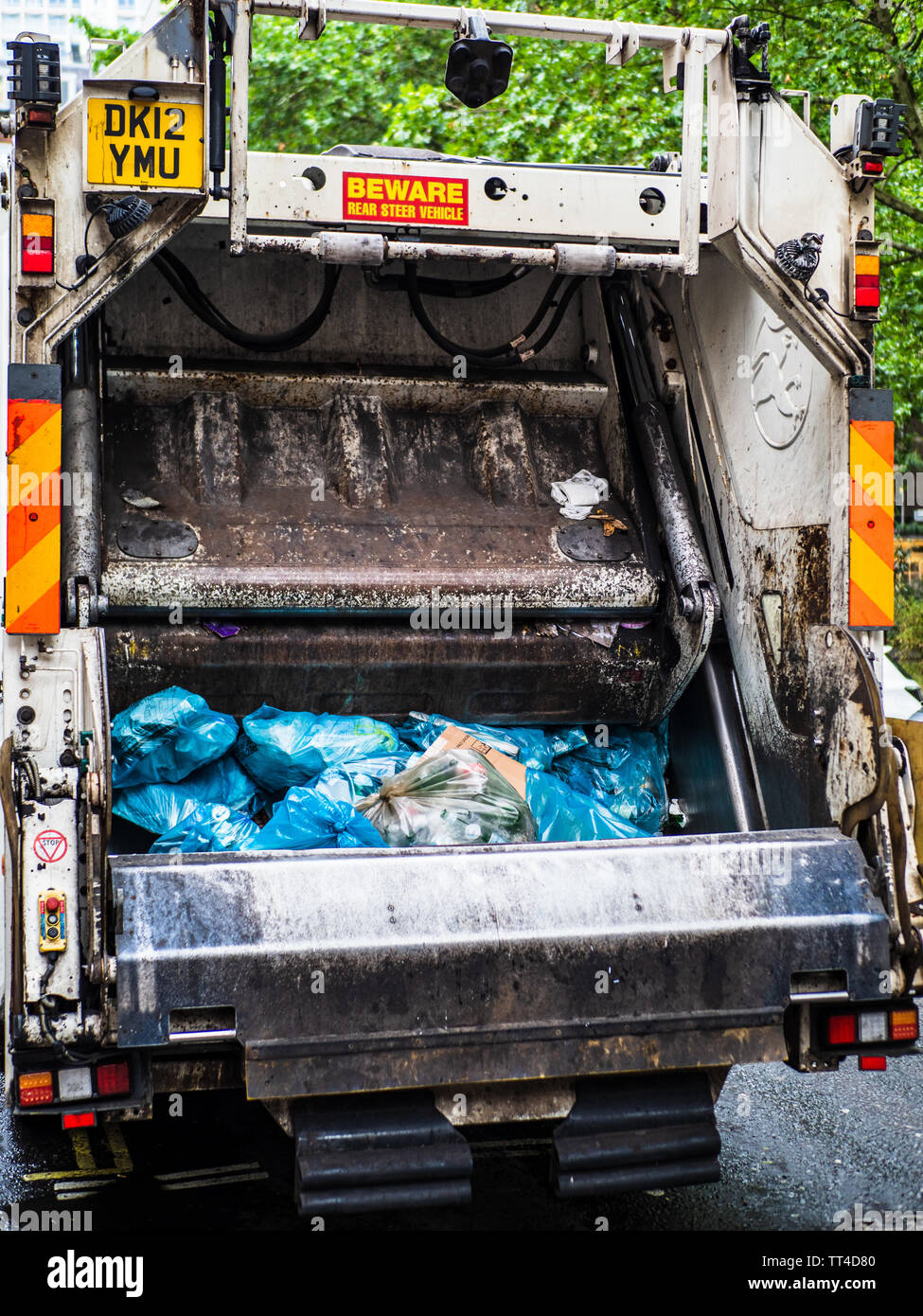 Refuse Collection Truck or Bin Lorry London - London Rubbish Truck picking up waste in Central London. Refuse Sack Collection. Bin Bag Collection. Stock Photo