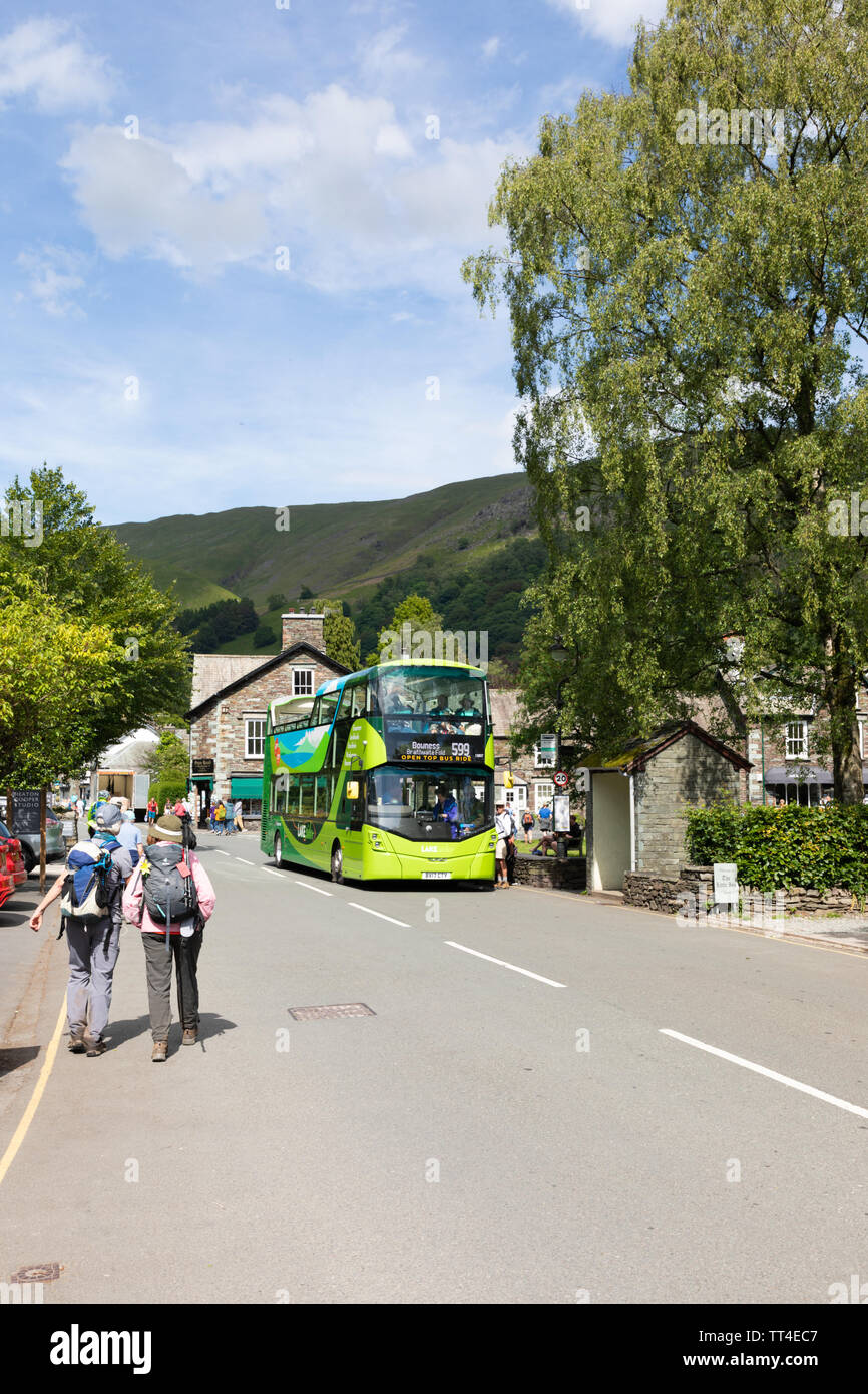 Grasmere, UK: An open-topped bus forming the 599 service between Grasmere and Bowness that's popular with tourists, picks up passengers in Grasmere. Stock Photo